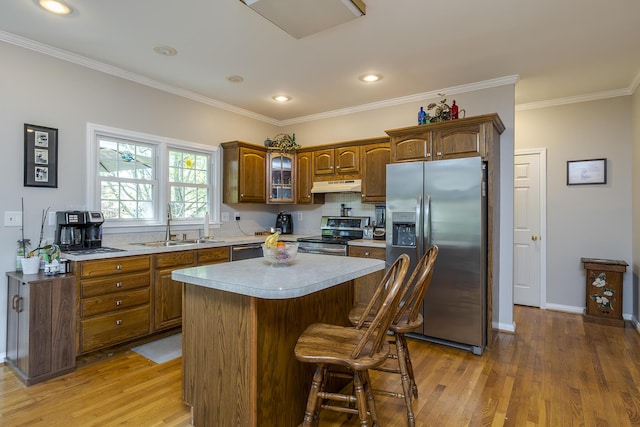 3120 Helmsdale Pl, Lexington, KY 40509 - kitchen featuring stainless steel appliances, a sink, light wood-type flooring, under cabinet range hood, and ornamental molding