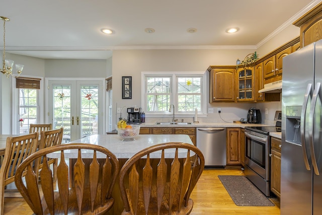 3120 Helmsdale Pl, Lexington, KY 40509 - kitchen with appliances with stainless steel finishes, a sink, brown cabinetry, light wood-type flooring, and glass insert cabinets