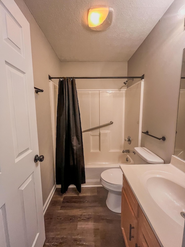 601 Heaton Ford Rd, Science Hill, KY 42553 - bathroom featuring a textured ceiling, wood finished floors, vanity, toilet, and shower / bath combo with shower curtain
