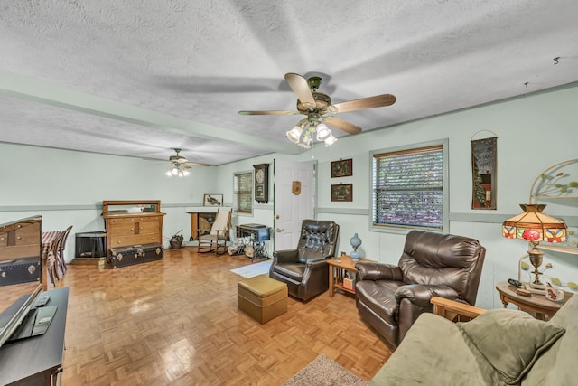 living area featuring a ceiling fan and a textured ceiling