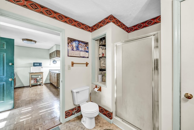 full bath with baseboards, toilet, and a shower stall