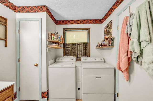 laundry area with a textured ceiling and washer and dryer