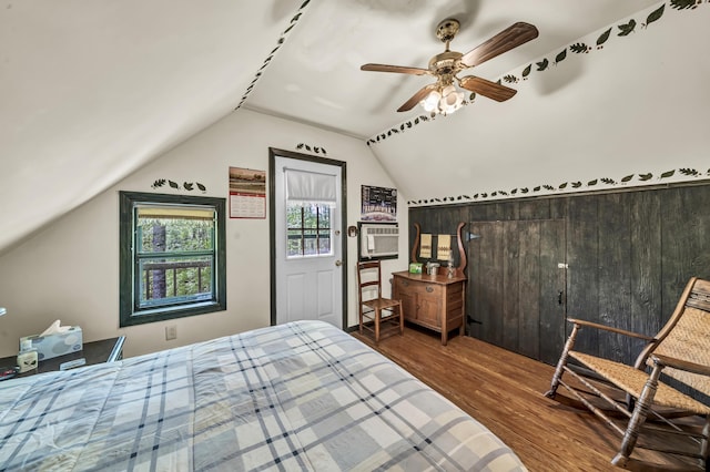 bedroom featuring ceiling fan, wood finished floors, vaulted ceiling, and cooling unit