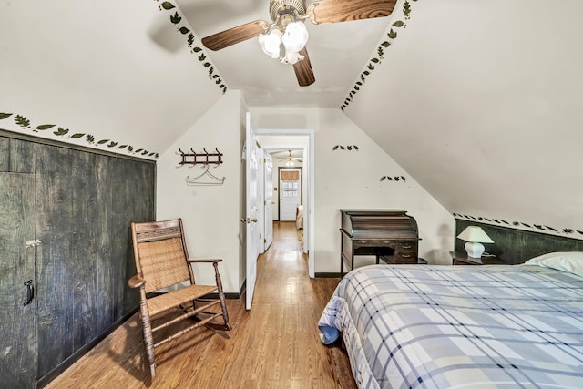 bedroom with baseboards, lofted ceiling, wood finished floors, and ceiling fan