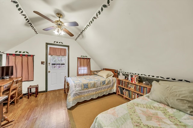 bedroom with baseboards, a ceiling fan, wood finished floors, and lofted ceiling