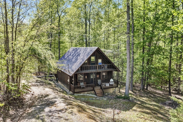 rustic home with a porch, metal roof, and a forest view