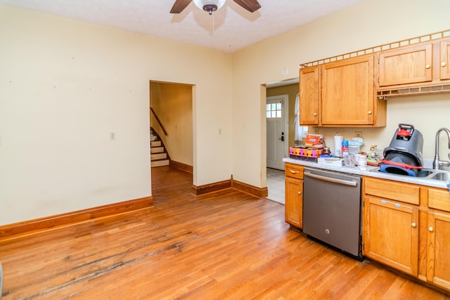 kitchen featuring stainless steel dishwasher, light wood finished floors, a ceiling fan, and a sink