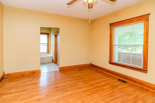 spare room featuring a ceiling fan, wood finished floors, and baseboards