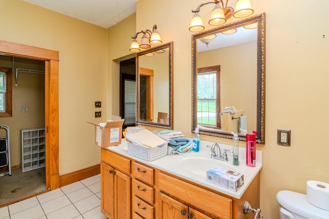 bathroom with toilet, vanity, and tile patterned floors