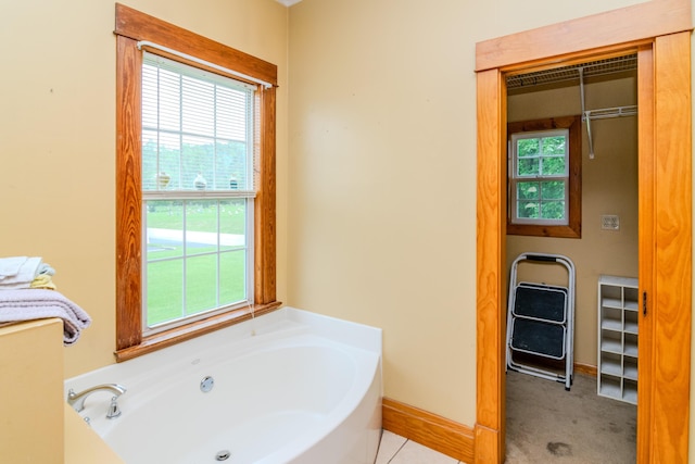 bathroom featuring a garden tub, healthy amount of natural light, and baseboards