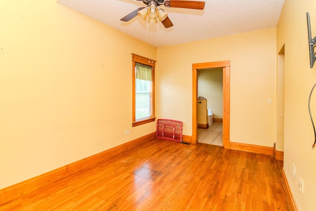 unfurnished room featuring light wood finished floors, ceiling fan, and baseboards
