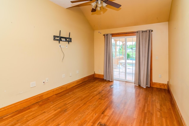 spare room featuring a ceiling fan, lofted ceiling, wood finished floors, and baseboards