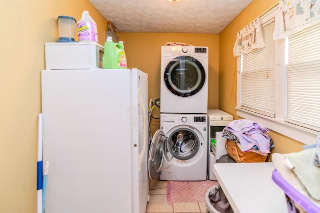 washroom featuring estacked washer and dryer, a textured ceiling, and light tile patterned floors