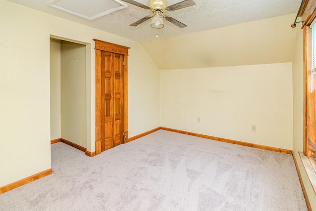 bonus room featuring carpet floors, lofted ceiling, baseboards, ceiling fan, and attic access
