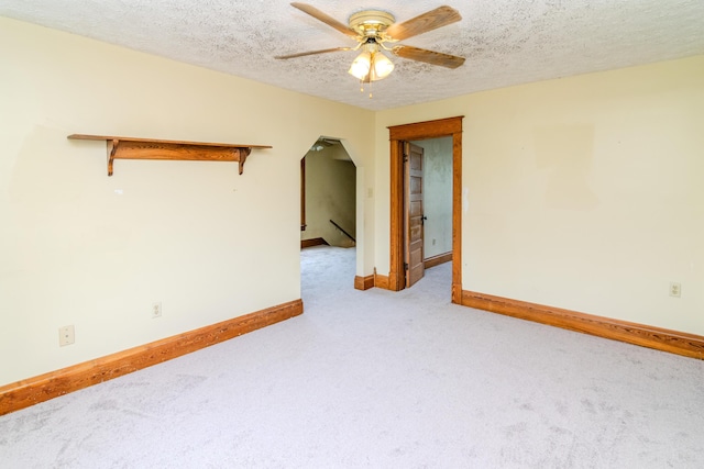 carpeted empty room featuring a ceiling fan, baseboards, and a textured ceiling