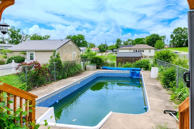 view of swimming pool with a fenced backyard and a residential view