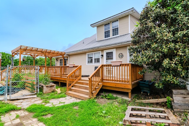 back of house featuring a garden, a wooden deck, metal roof, and a pergola