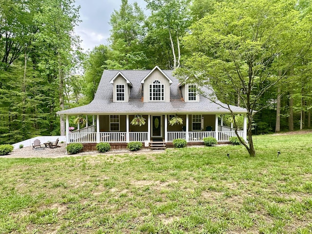 farmhouse inspired home with a porch, a front yard, and roof with shingles