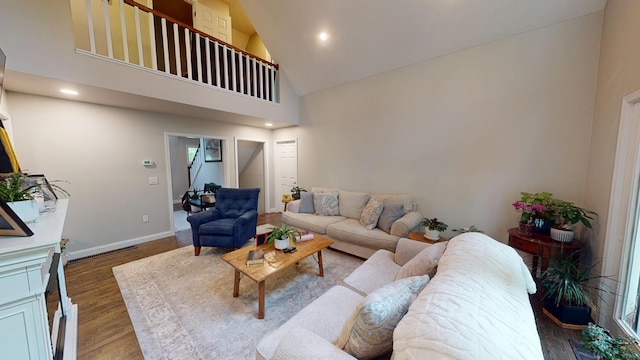 living room with wood finished floors, recessed lighting, high vaulted ceiling, and baseboards