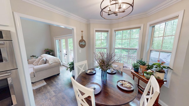 dining space with ornamental molding, a chandelier, and plenty of natural light