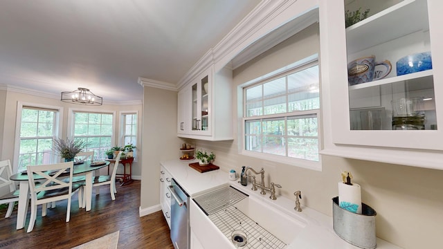 kitchen featuring an inviting chandelier, stainless steel dishwasher, glass insert cabinets, a sink, and white cabinetry