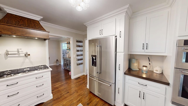 kitchen featuring stainless steel appliances, white cabinets, dark wood-style flooring, baseboards, and crown molding
