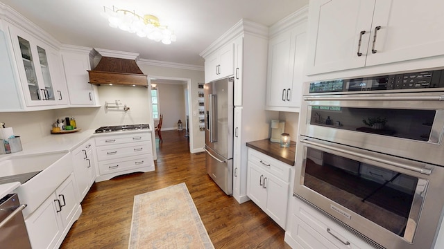 kitchen featuring white cabinetry, stainless steel appliances, dark wood-style floors, and premium range hood