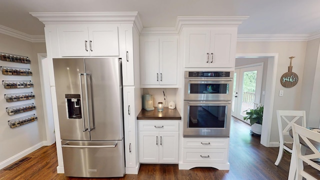 kitchen featuring dark wood finished floors, appliances with stainless steel finishes, white cabinets, baseboards, and visible vents