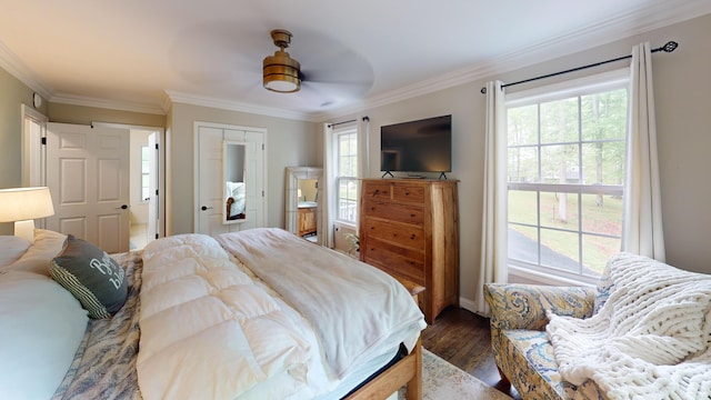 bedroom featuring ornamental molding, dark wood-style floors, and multiple windows