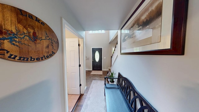 hallway with tile patterned flooring, stairs, and baseboards