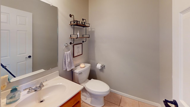 half bath featuring baseboards, toilet, tile patterned flooring, and vanity