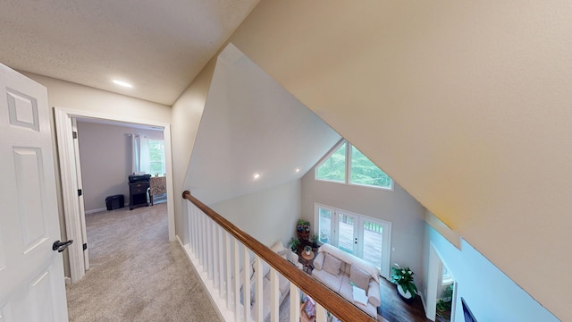 corridor with an upstairs landing, recessed lighting, and light carpet
