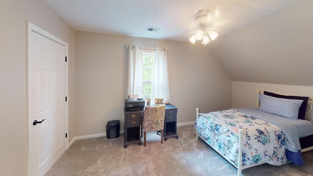 carpeted bedroom with visible vents, vaulted ceiling, and baseboards