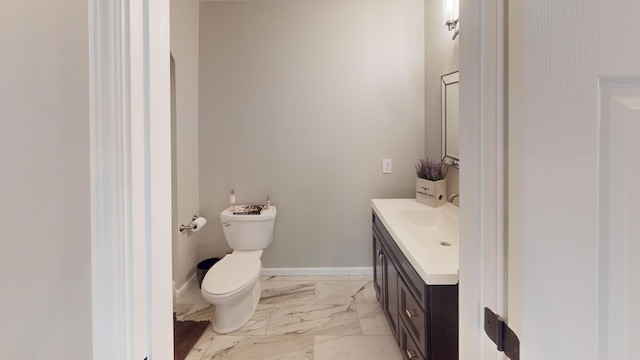 bathroom featuring baseboards, toilet, vanity, and marble finish floor