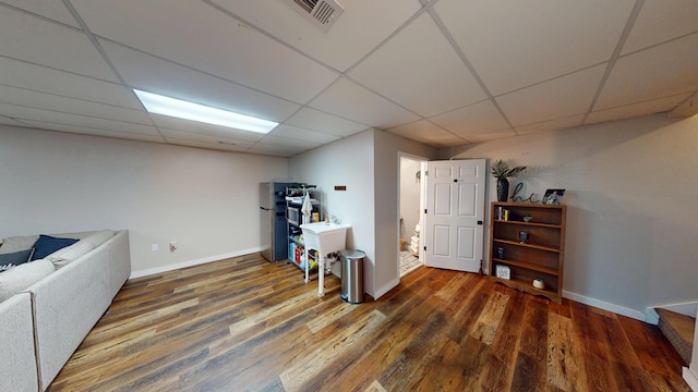 basement featuring wood finished floors, a paneled ceiling, and baseboards