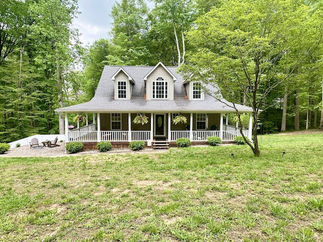 farmhouse-style home featuring a porch, a front yard, and roof with shingles