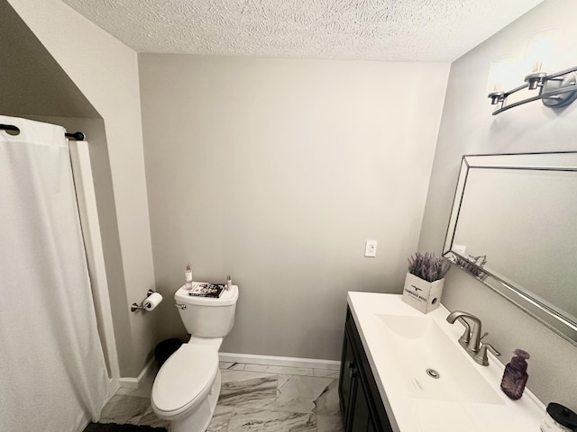 bathroom with toilet, a textured ceiling, vanity, and marble finish floor
