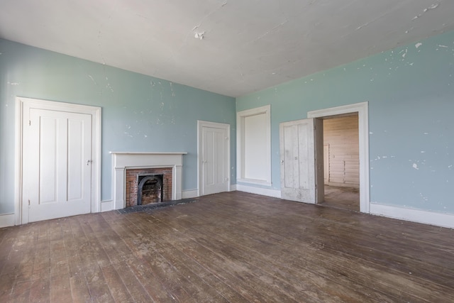 unfurnished living room with a fireplace, baseboards, and wood-type flooring