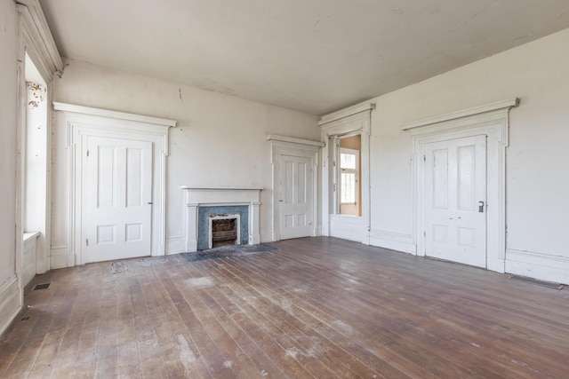 unfurnished living room featuring visible vents, hardwood / wood-style flooring, and a high end fireplace