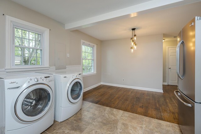 washroom featuring baseboards, wood finished floors, and independent washer and dryer