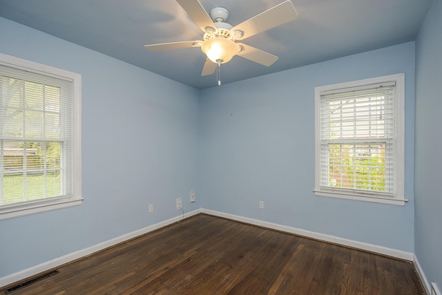 empty room with visible vents, a wealth of natural light, and baseboards