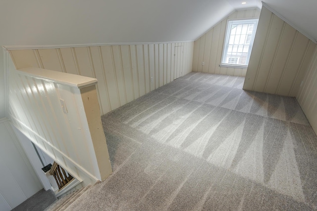 bonus room with a decorative wall, carpet flooring, and lofted ceiling