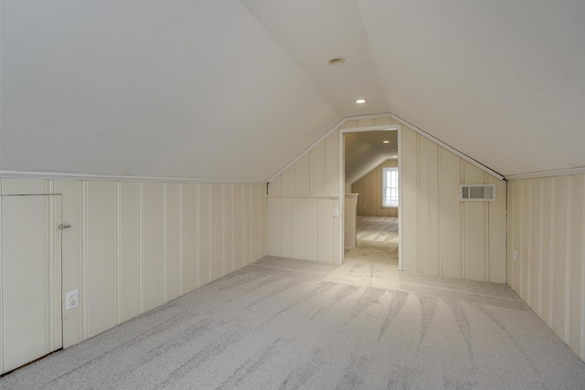 additional living space featuring lofted ceiling, visible vents, and carpet floors