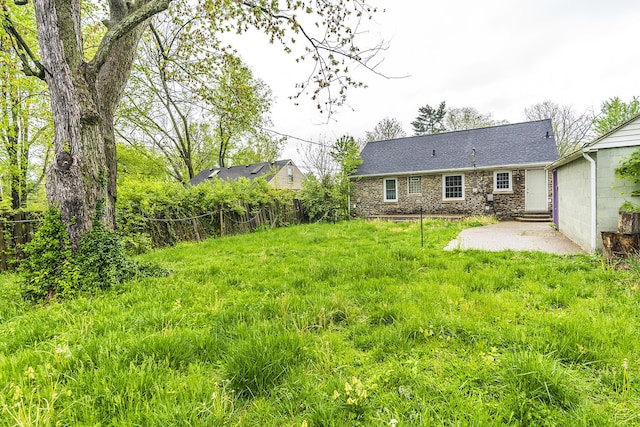 back of property with stone siding, entry steps, and fence