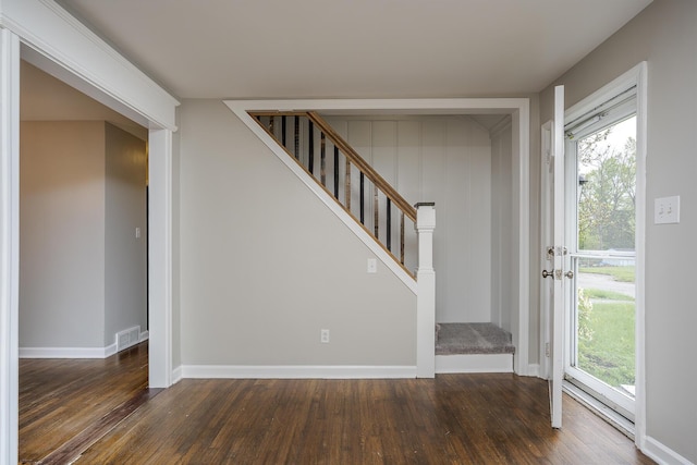 entryway with baseboards, visible vents, wood finished floors, and stairs