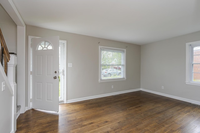 entrance foyer featuring dark wood-style floors, stairs, visible vents, and baseboards