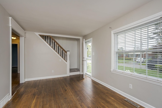 interior space featuring visible vents, stairway, wood finished floors, and baseboards