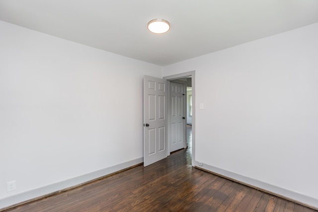 unfurnished room with dark wood-style floors and baseboards