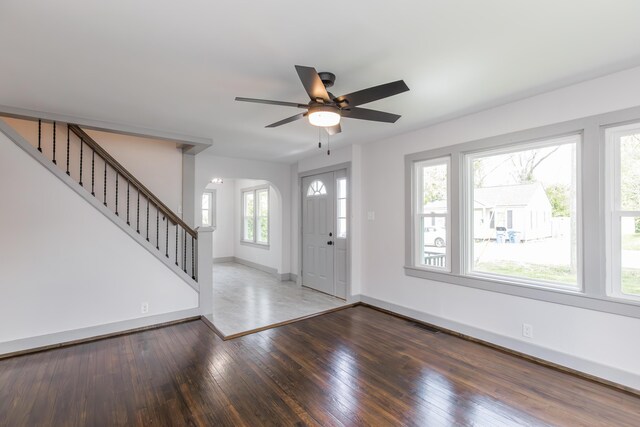 foyer entrance with stairway, a ceiling fan, wood-type flooring, and baseboards