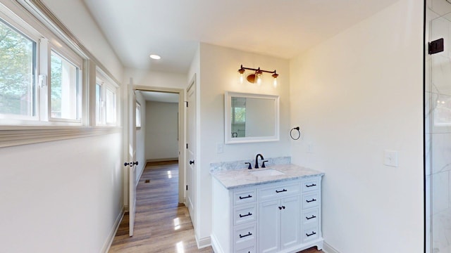 bathroom with vanity, recessed lighting, baseboards, and wood finished floors